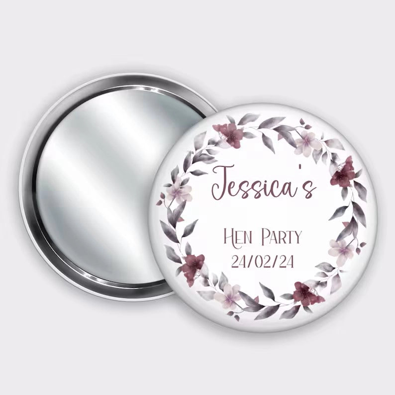 Personalised pocket badge mirror for hen party favours, featuring name and hen party date with a burgundy floral wreath.