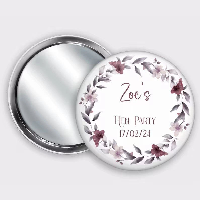 Personalised pocket badge mirror for hen party favours, featuring name and hen party date with a burgundy floral wreath.