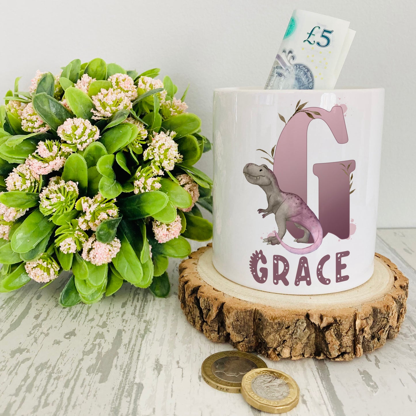 Personalised ceramic money box with a lilac dinosaur alphabet design